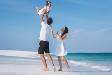 Young family with little daugher on a vacation by the ocean